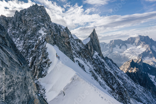Fotografie, Obraz Climbers or alpinist on a knife sharp ridge of an alpine peak or summit of Aiguille du Rochefort