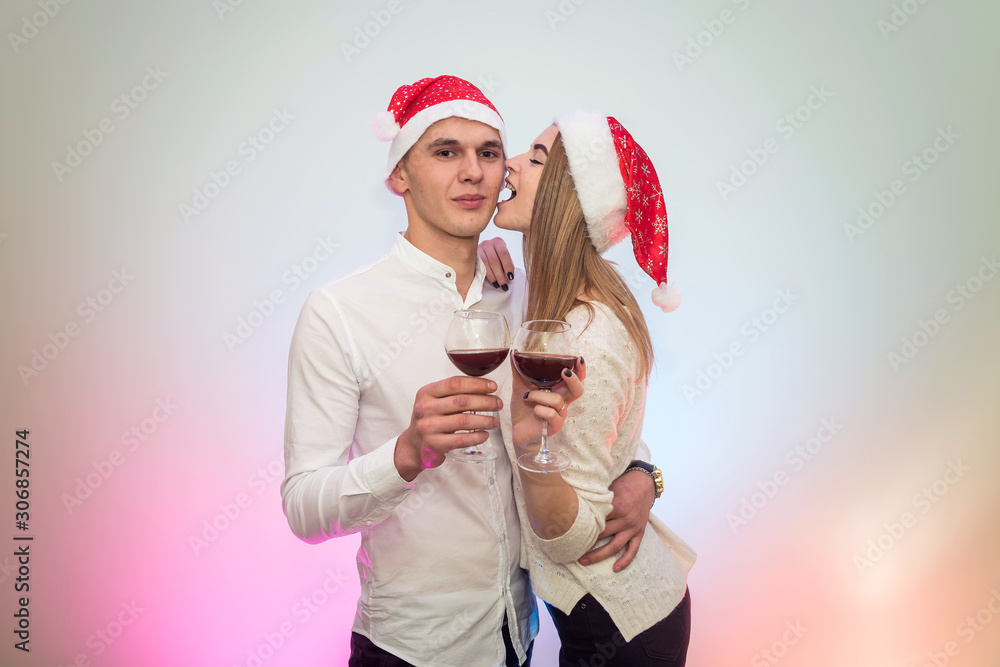 Obraz premium Young man pouring wine into glasses to his girlfriend. Valentine's celebration concept