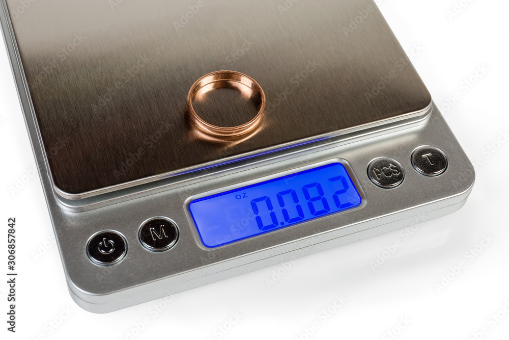 Fototapeta premium Fragment of professional digital table scales with gold ring closeup