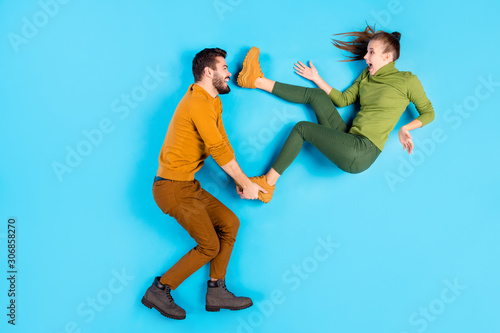 Profile side top above high angle view full length body size photo of cheerful positive beautiful spouses with man throwing his girl away playing waiting for her to fall isolated pastel blue color