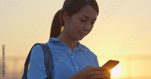 Photography Asian Woman use of cellphone under sunset in Hong Kong