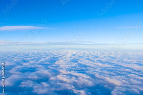 Aerial view from an airplane on clouds and a blue sky. Tourism and Travel. Desktop backgrounds, textures.