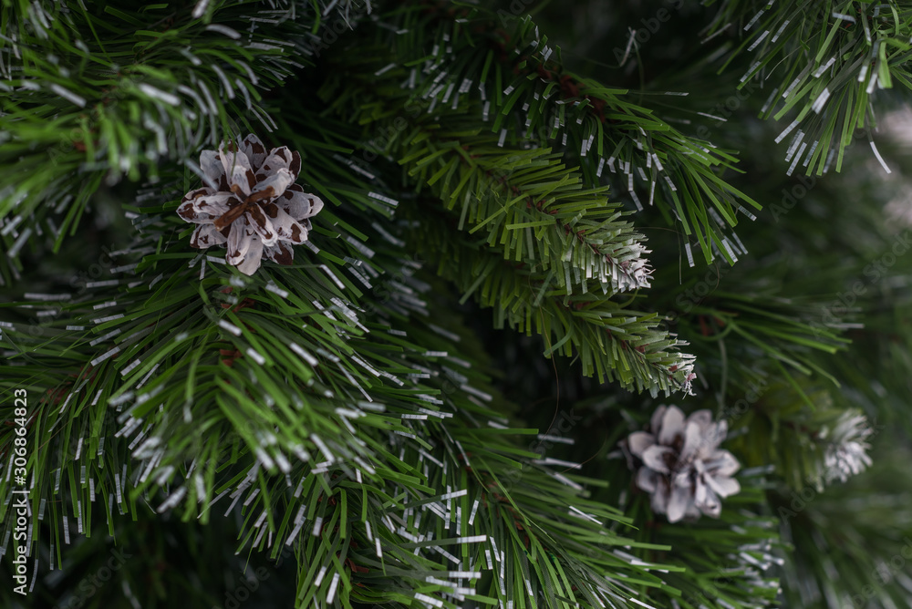 Artificial Christmas tree with white cones. Winter background for advert, promotion.