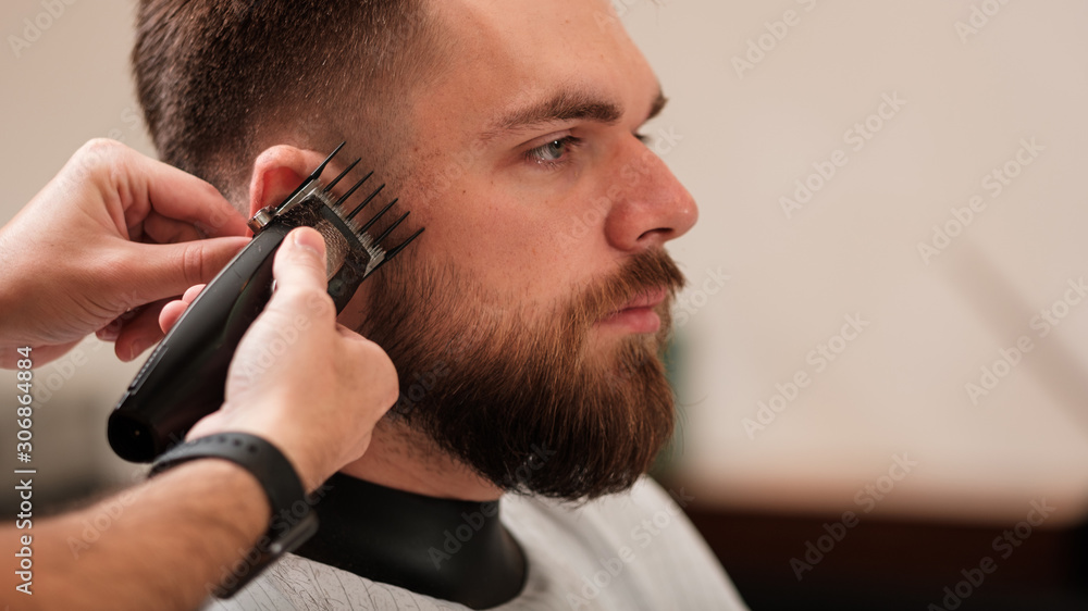 a man haircuts a machine at a hairdresser in a barbershop. shave your head a man haircuts a machine at a hairdresser in a barbershop. shave your head