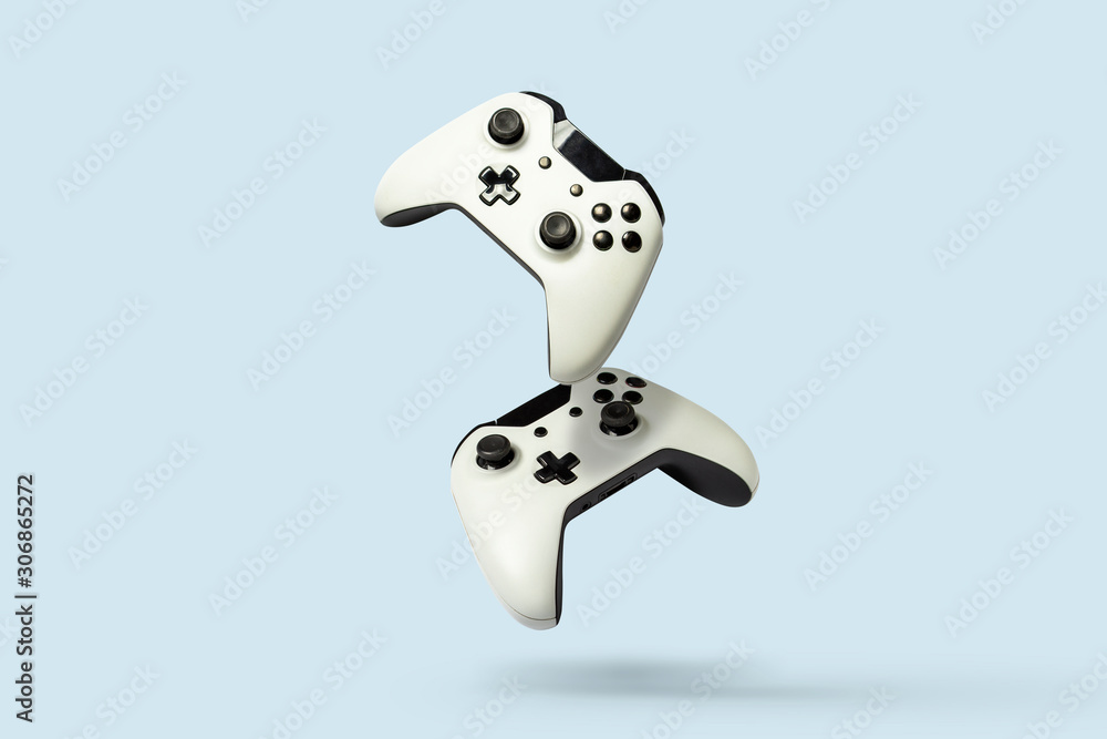 Flying air gamepads from a game console on a blue background. The concept of games, online games, e-sports. Levitation - obrazy, fototapety, plakaty 