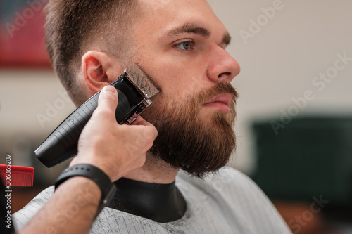 haircut beard typewriter. beard trimmer. Barber services. The man in the barbershop