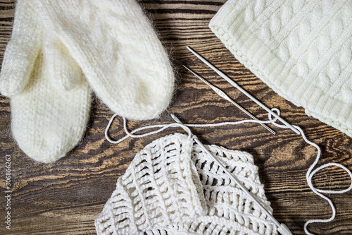 Winter background. Knitting, crochet. White mittens and hat.