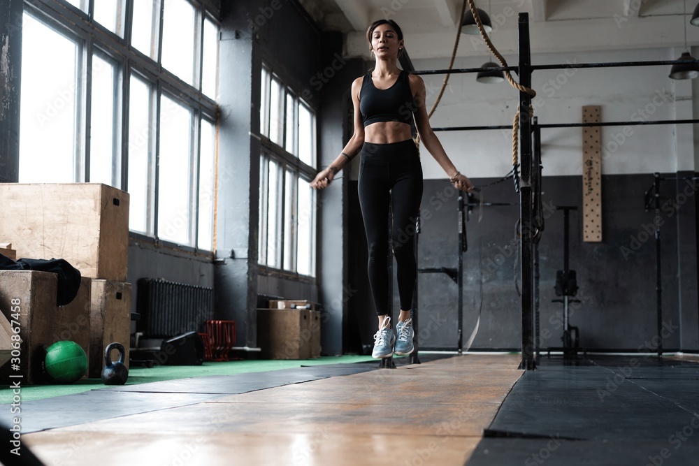 beautiful sporty woman workout with jumping rope in crossfit gym. beautiful sporty woman workout with jumping rope in crossfit gym.