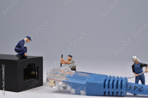 Mini workers are trying to fit a nethernet plug in a connector