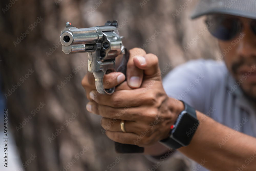 Man holding gun aiming pistol in hand ready to shoot. The criminal robber or gangster thief concept Man holding gun aiming pistol in hand ready to shoot. The criminal robber or gangster thief concept