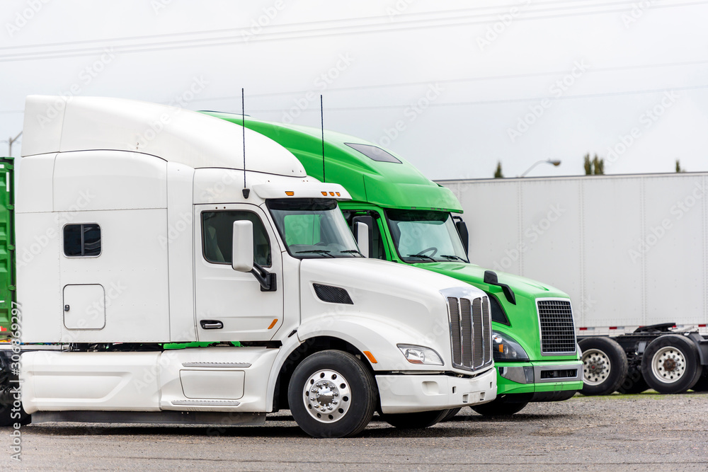 Profile of different big rig semi trucks standing on parking lot waiting for a commercial load