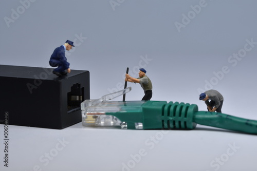 Mini workers are trying to fit a nethernet plug in a connector