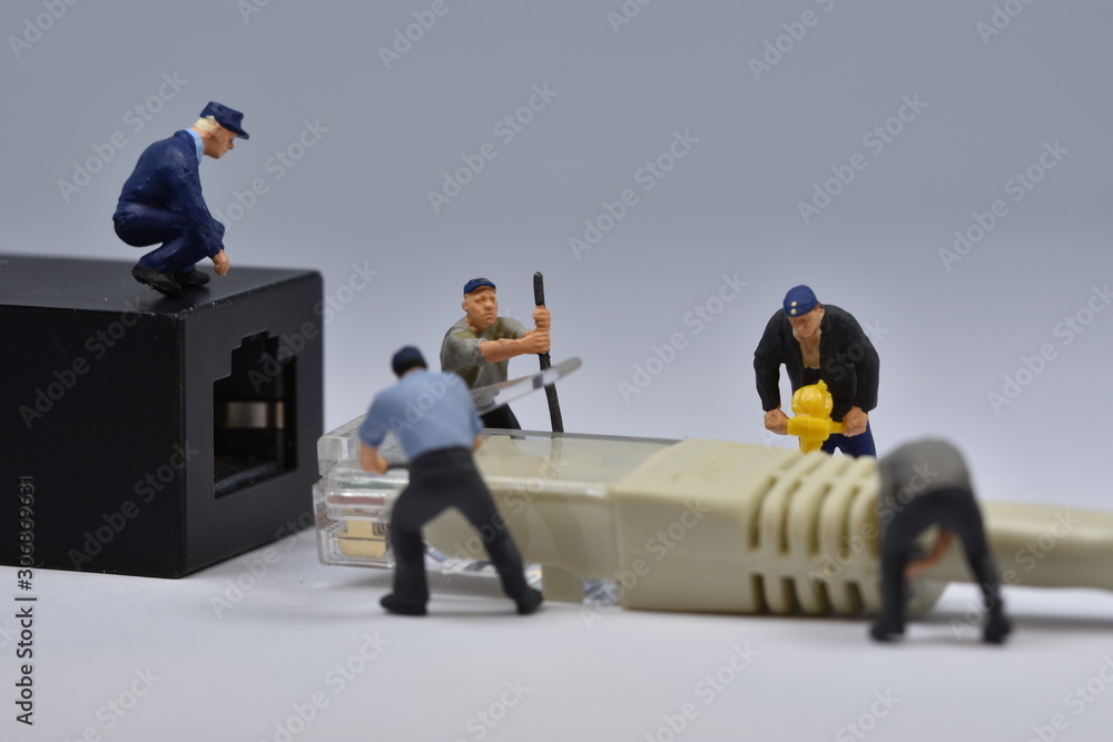 Mini workers are trying to fit a nethernet plug in a connector Mini workers are trying to fit a nethernet plug in a connector