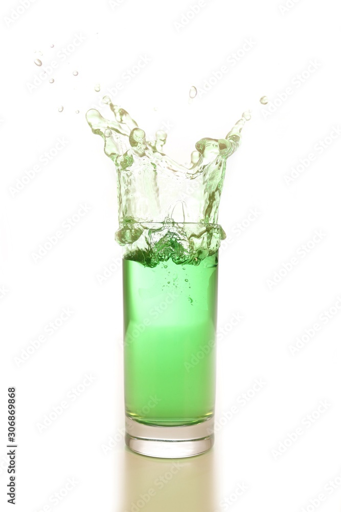 green water or drink splash out of a glass isolated on white background green water or drink splash out of a glass isolated on white background