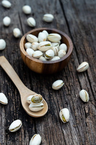 Pistachio nut in wooden bowl on rusty wood table background