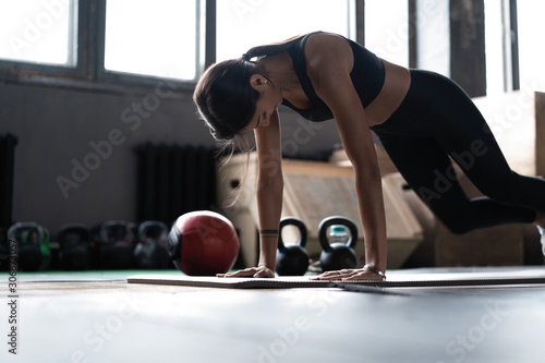 Woman doing planks on gym floor. Healthy lifestyle concept