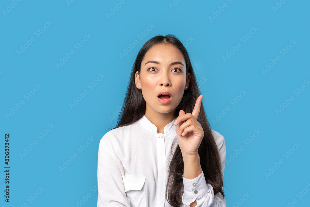 Freestyle. Young woman wearing shirt and skirt standing isolated on blue finger up mouth opened inspired with new idea Freestyle. Young woman wearing shirt and skirt standing isolated on blue finger up mouth opened inspired with new idea