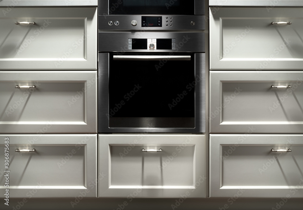 metal and black glass modern oven with screen and buttons in empty kitchen interior metal and black glass modern oven with screen and buttons in empty kitchen interior