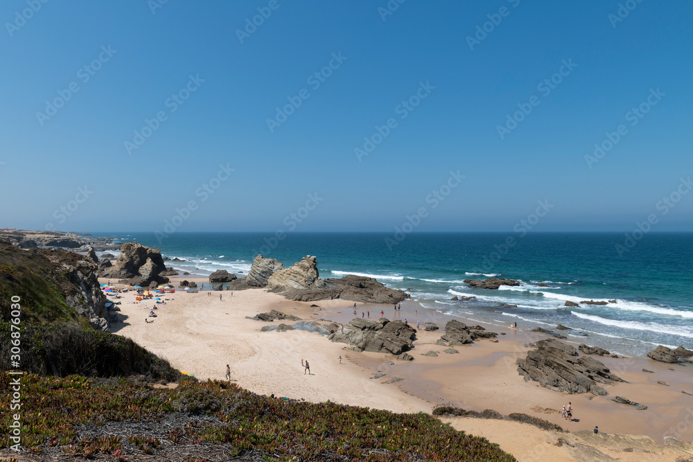People at the beach during the summer in Porto Covo, in Alentejo, Portugal.