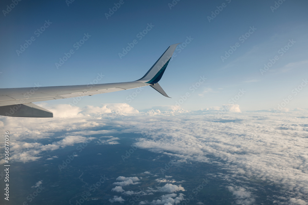 View of wing airplane on cloudy in blue sky View of wing airplane on cloudy in blue sky