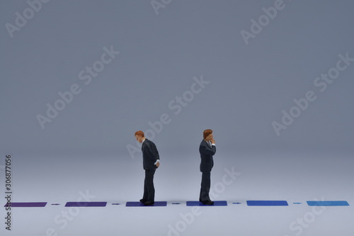 Mini business men standing on paper with blua and purple lines printed on it