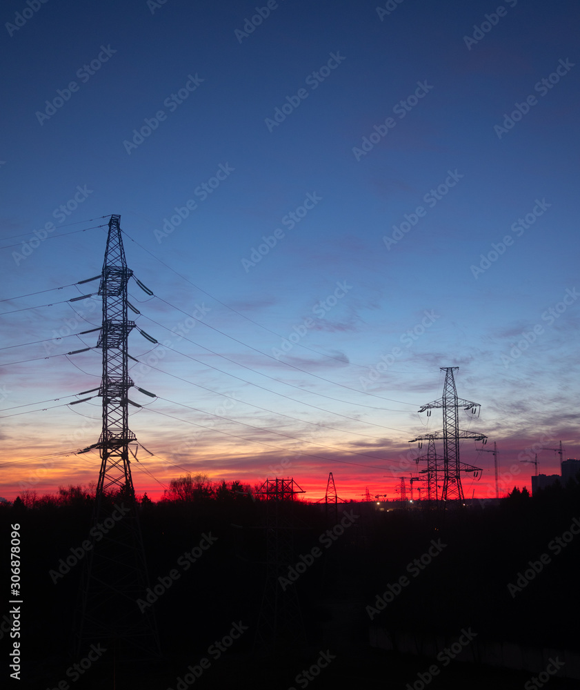 Power lines on a pink sky background. Sunrise over the forest