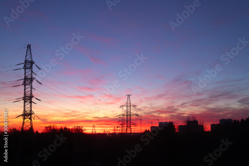 Power lines on a pink sky background. Sunrise over the forest