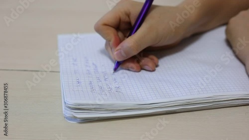 Hands of a man holding a pen and writes a note.
