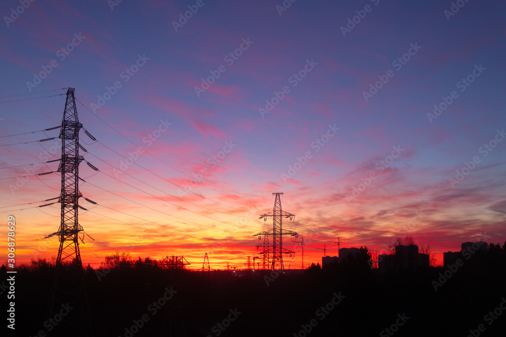 Power lines on a pink sky background. Sunrise over the forest