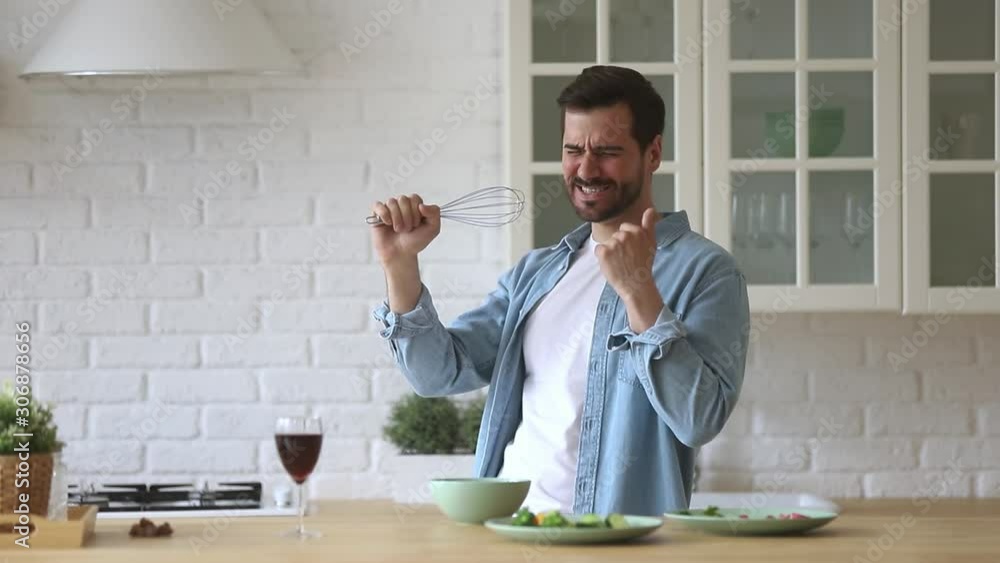Funny man singing in beater microphone dancing cooking in kitchen Funny man singing in beater microphone dancing cooking in kitchen