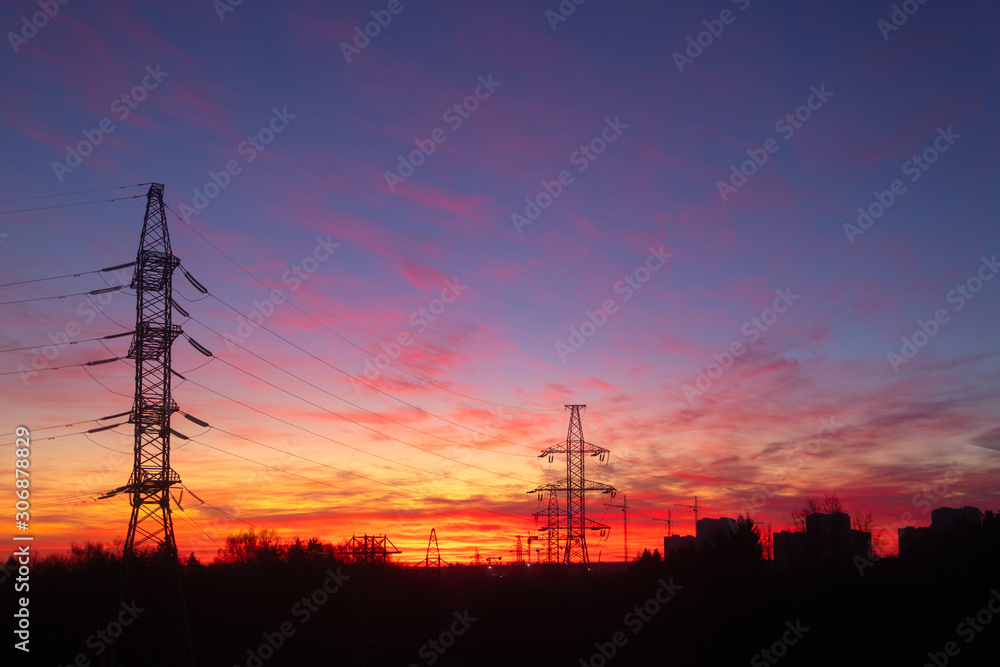 Power lines on a pink sky background. Sunrise over the forest