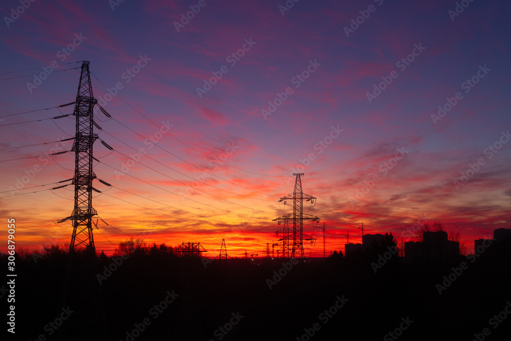 Power lines on a pink sky background. Sunrise over the forest