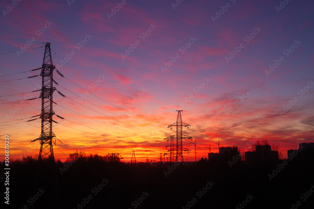 Power lines on a pink sky background. Sunrise over the forest