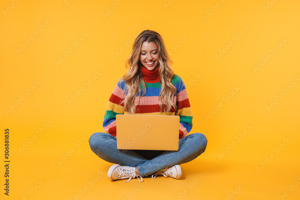 Image of blonde woman using laptop computer while sitting on floor Image of blonde woman using laptop computer while sitting on floor