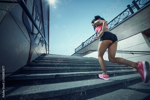 Athletic young woman jogging up the stairs.