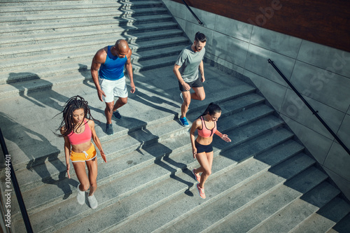 Athletic young people jogging on a stairs.