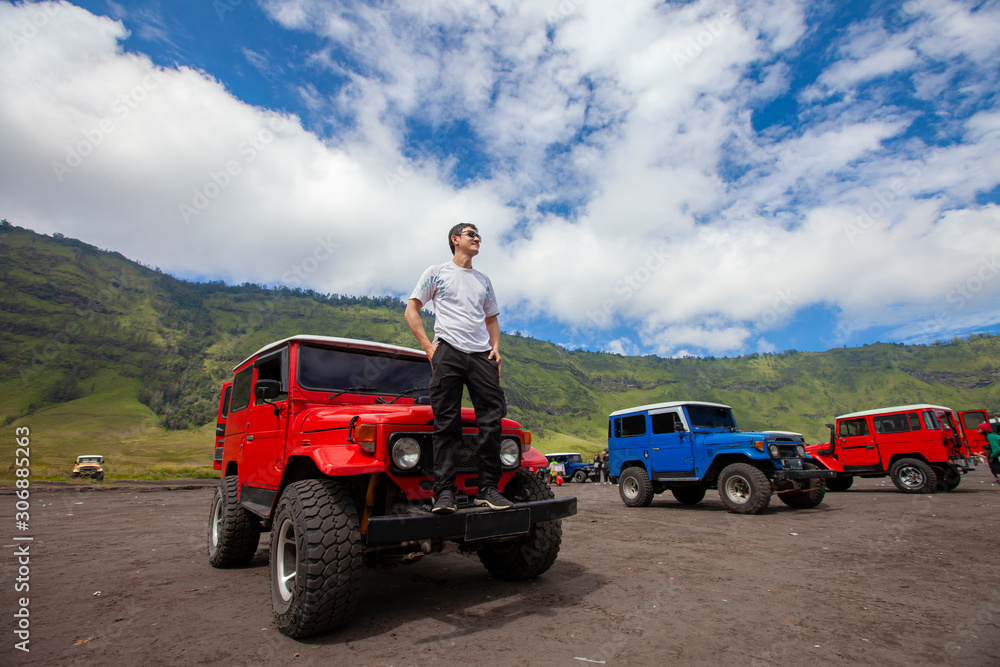 Mt.Bromo, Pasuruan, East Java, Indonesia - Man with 4wd car on Adventure driving Off-road Jeep 4WD into Beautiful active Volcano with smoke Mount Bromo.