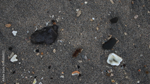 the rocks on the beach sand are gray in the morning, with less light, out of focus, suitable for the background photo