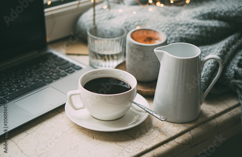 Cozy freelancer's winter work place at home with cup of coffee