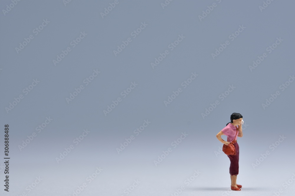 miniatuur woman standing is talking on a handy miniatuur woman standing is talking on a handy