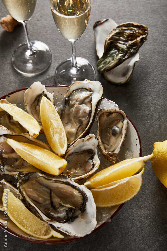Φωτογραφία top view of delicious oysters and lemons in bowl near champagne glasses with spa