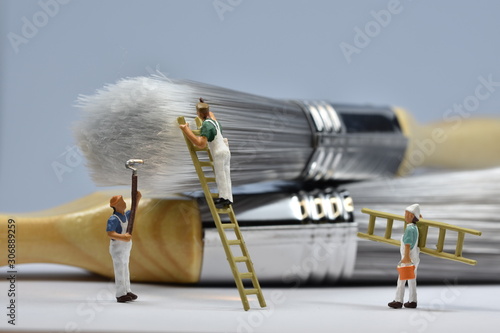 tiny painters are painting. Standing on a ladder, walking around brushes