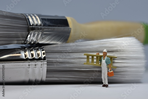 tiny painters are painting. Standing on a ladder, walking around brushes