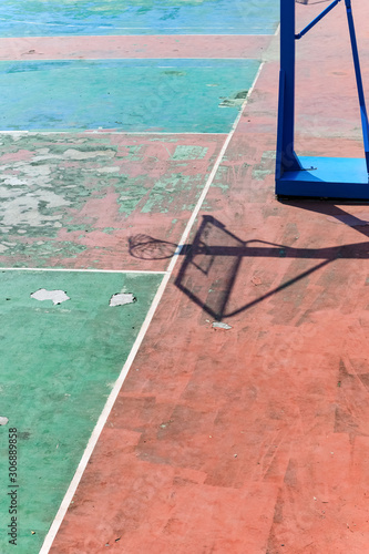 basketball frame and its shadow in an outdoor court vertical composition