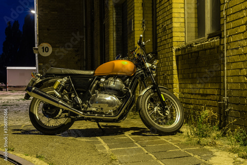 A motorcycle at night, a motorcycle stands under a street light, cruiser, vintage motorcycle