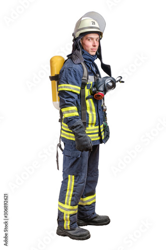 Young fireman with a mask and an air breathing apparatus on his back in a fully protective suit