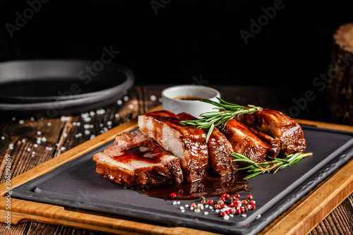 American food concept. Grilled pork ribs with grilled sauce, with smoke, spices and rosemary. Background image. copy space photo