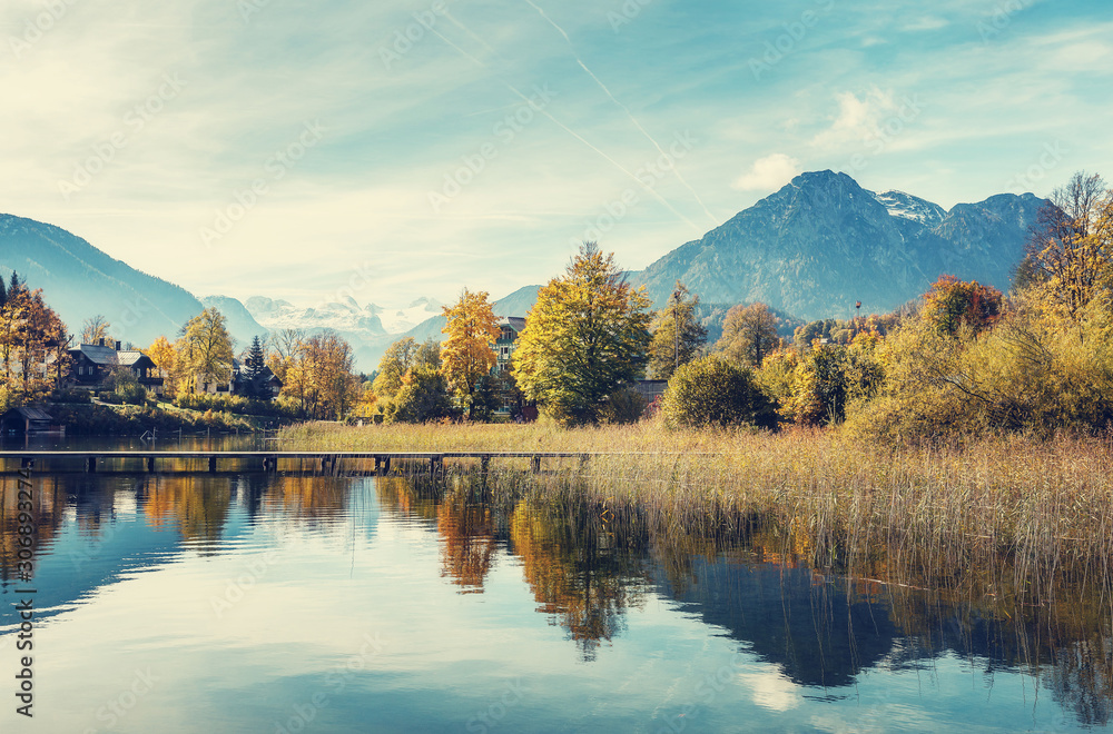 Unsurpassed autumn landscape at Austrian Alps. Majestic Dachstein, under sunlit. and Famous lake Altausseer See. Incredible alpine Landscape. Picturesque view of nature. Wonderful natural background.