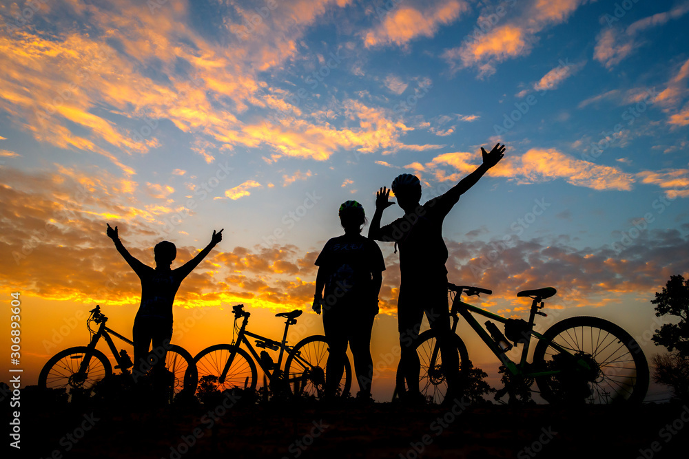 Family cyclist and Bicycle silhouettes on the dark background of sunsets Family cyclist and Bicycle silhouettes on the dark background of sunsets