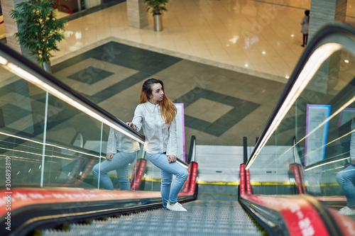 young woman on an escalator in a shopping center